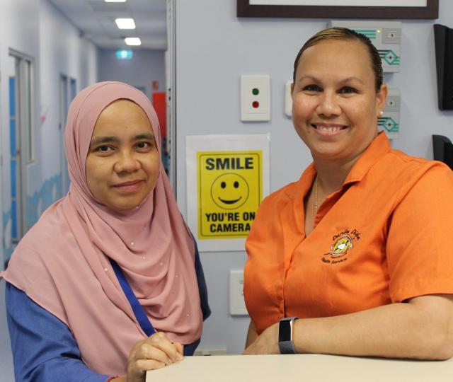 Two Danila Dilba Rapid Creek clinic staff members smile for a photo inside the clinic.